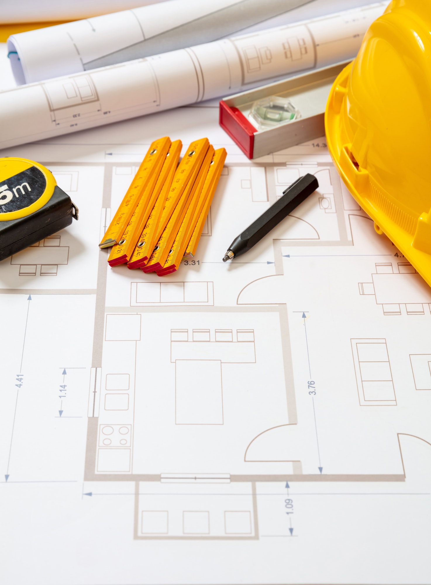 Construction concept. Residential building drawings and hardhat on an office desk